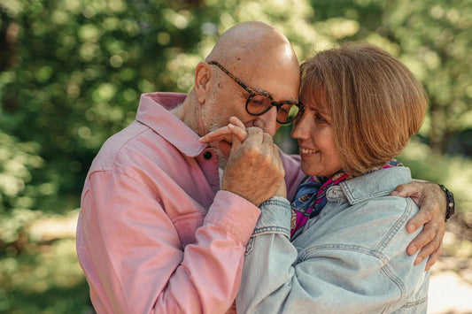 A senior couple shares a loving embrace outdoors, capturing tender affection