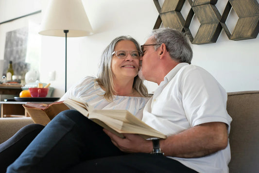Senior couple relaxing and enjoying a book together indoors