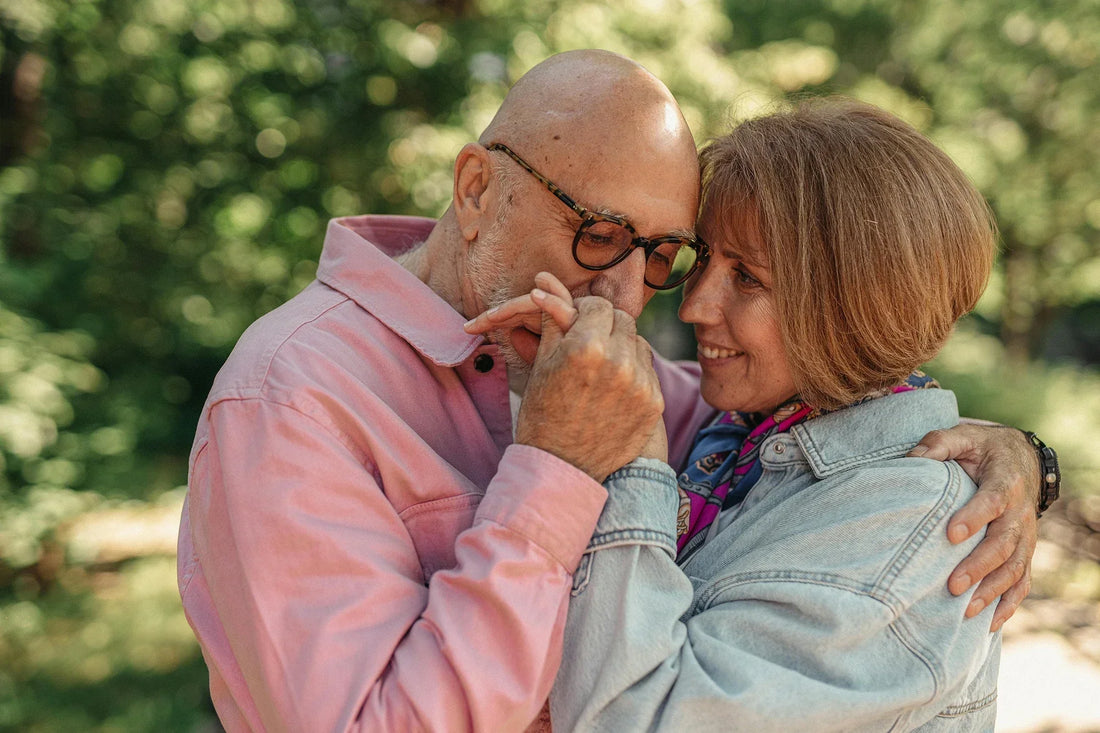 A senior couple shares a loving embrace outdoors, capturing tender affection