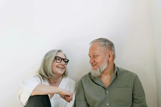 An elderly couple sharing a loving moment with smiles indoors.
