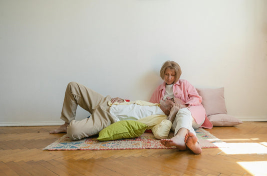 Senior couple enjoying quiet time indoors, relaxing on floor with pillows at home