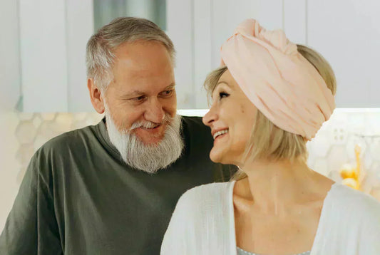 An older couple smiling and sharing a happy moment together in the kitchen.