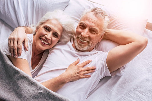 Happy senior couple in bed smiling